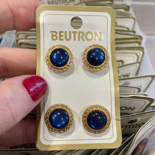 Blue buttons on a Beutron card held by a hand with red nail polish.
