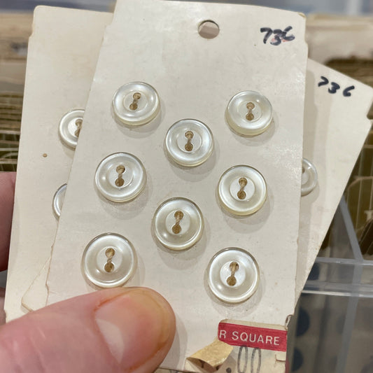 Hand holding a card with buttons against a blurred background