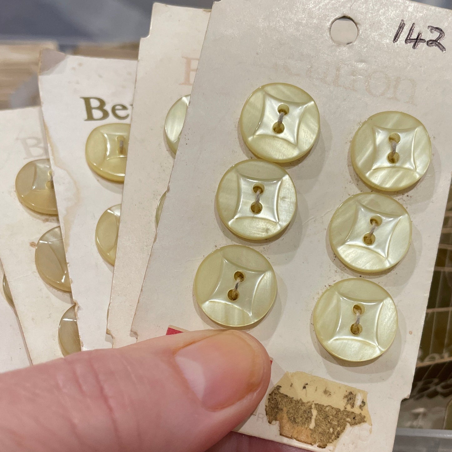 Hand holding a card with gold buttons against a blurred background