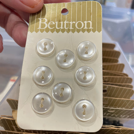 Card with pearl buttons held by a hand, with a blurred background