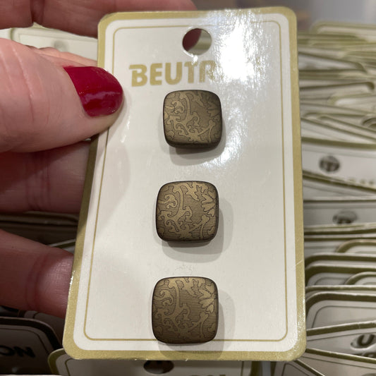 Hand holding a card with three small square buttons labeled 'BEUTON' against a background of similar cards.