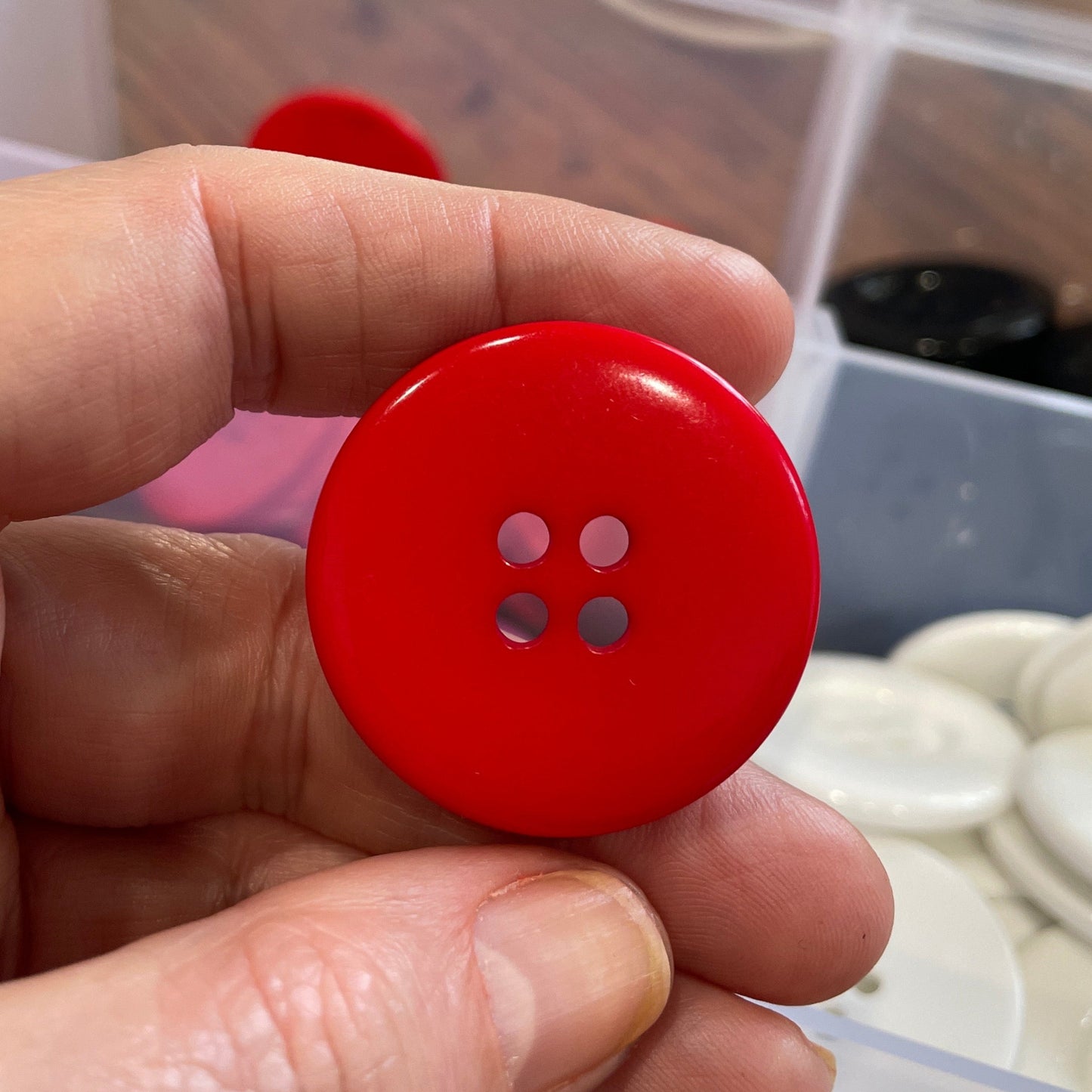 Hand holding a red button with a blurred background