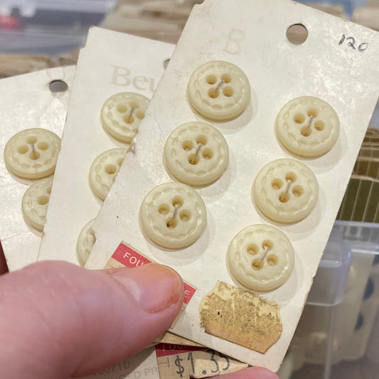 Hand holding a card with button designs against a blurred background