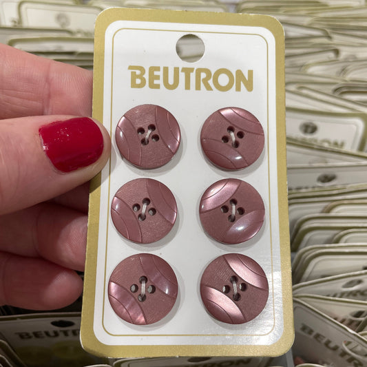 Set of six brown buttons on a BEUTRON card held by a hand with red nail polish.