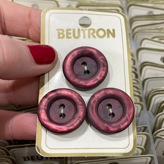 Hand holding a card with red buttons against a background of similar cards.