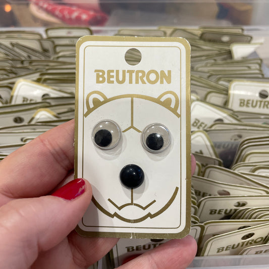 Hand holding a Beutron  with packaging in the background