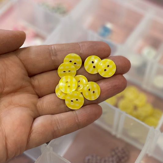 Hand holding yellow buttons with a blurred background