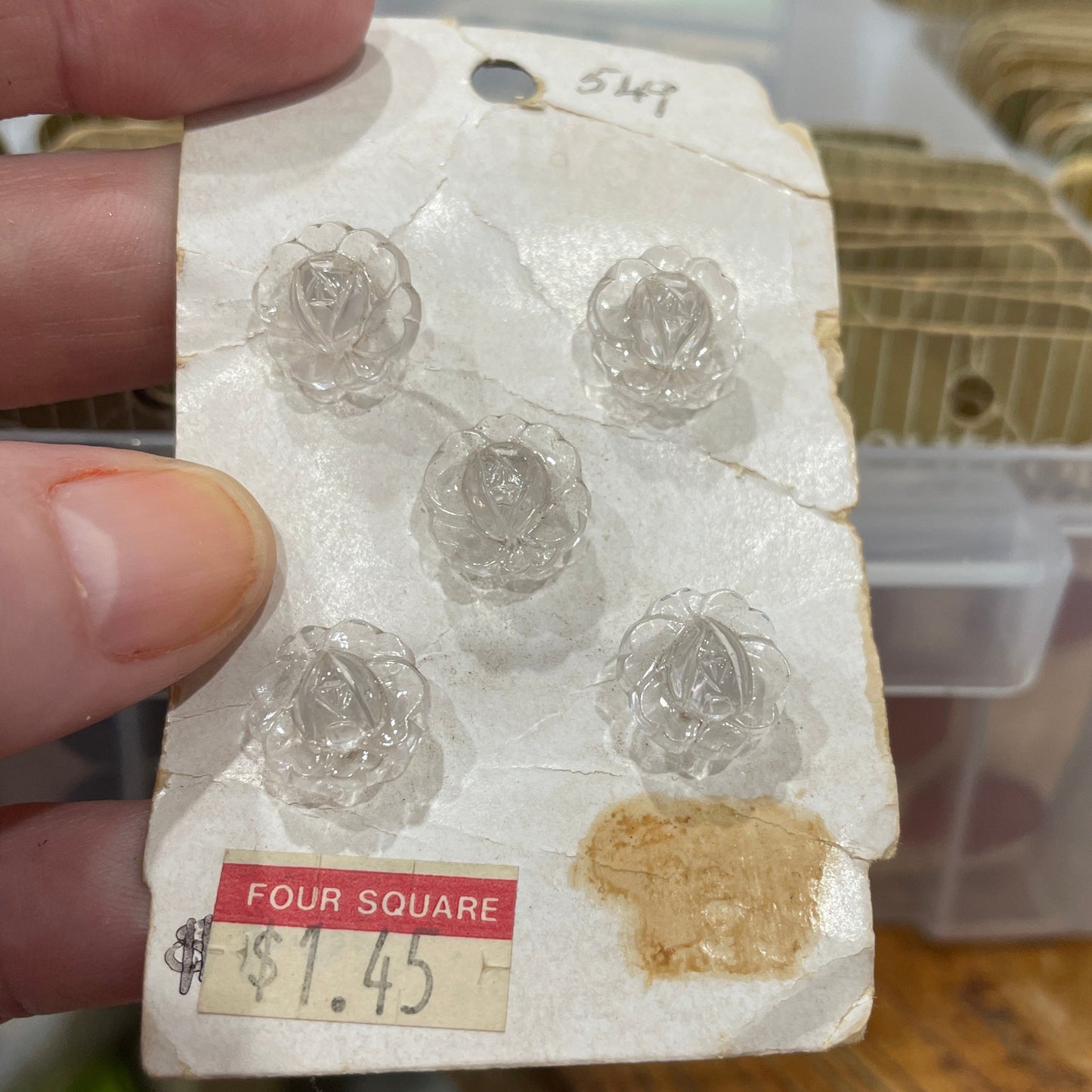 buttons in a holder with a price tag held by a hand