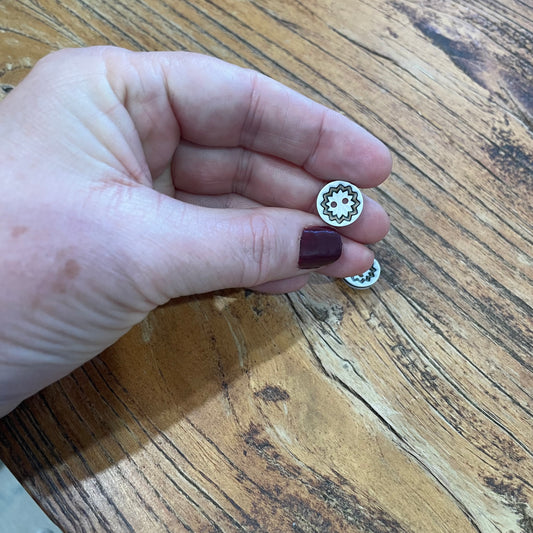 Small decorative button held between fingers on a wooden surface