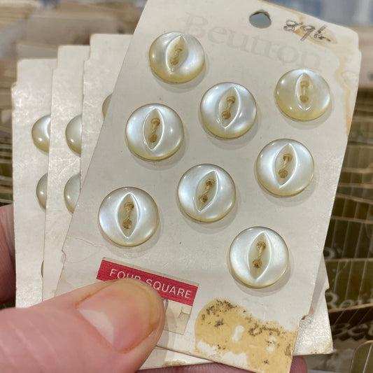 Hand holding a card with white buttons and a blurred background