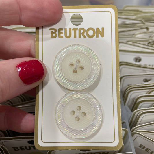 Beutron buttons on a card held by a hand with red nail polish.