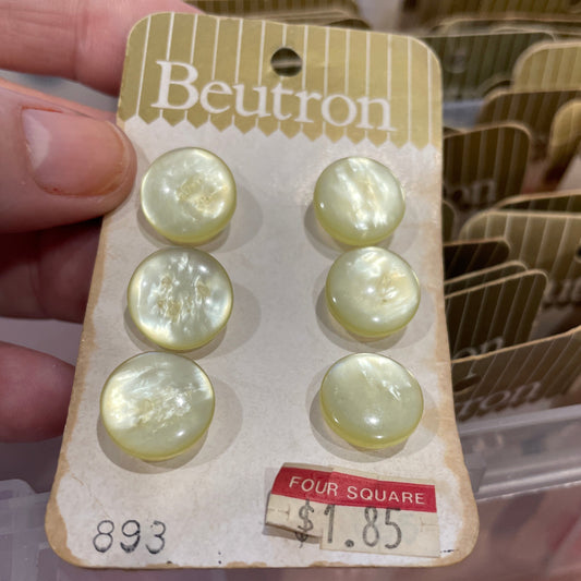 Packaged buttons with a visible price tag held by a hand