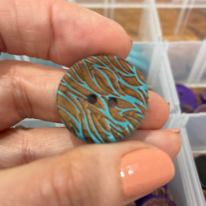 Hand holding a blue and brown patterned object with storage containers in the background
