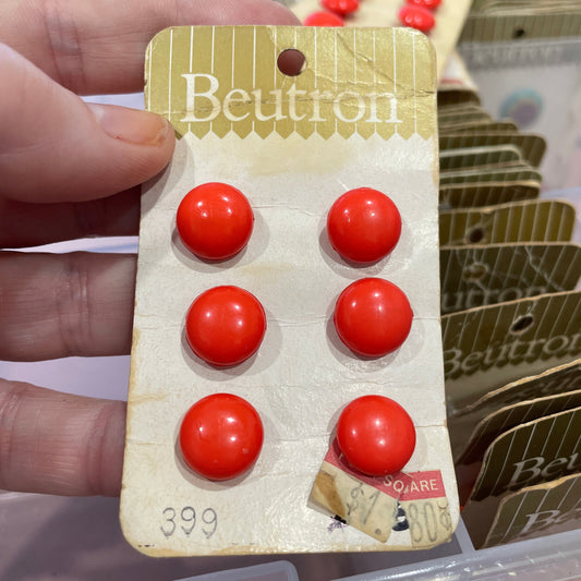 Hand holding  red buttons, against a blurred background.