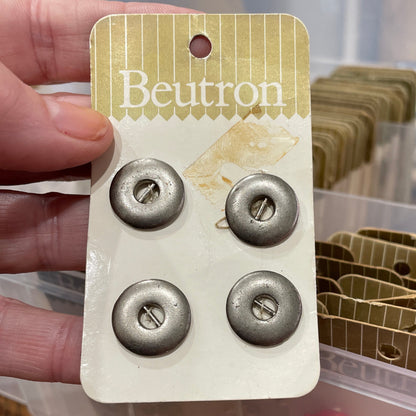 Packaged buttons held by a hand with a blurred background