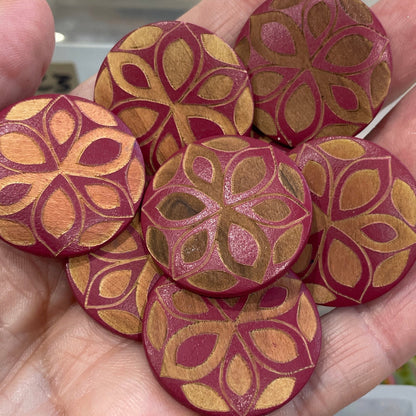 Hand holding decorative buttons with a background of button collection