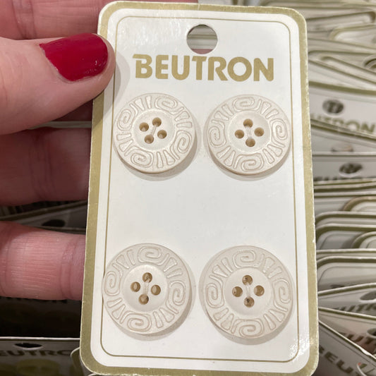 Beutron buttons on a card held by a hand with red nail polish.
