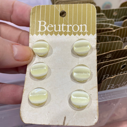 Beutron buttons  on a card held by a hand with a blurred background