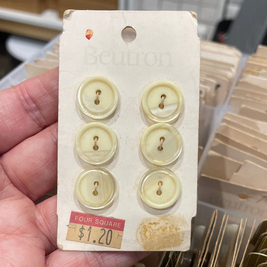 Set of yellow buttons on a card held by a hand with a blurred background