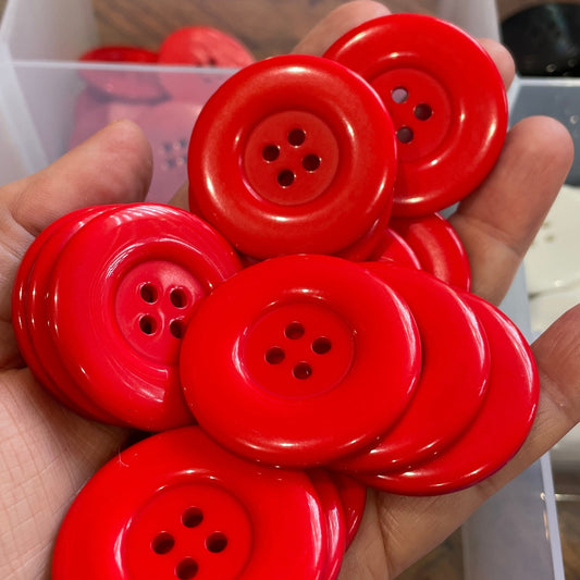 Hand holding a cluster of red buttons with a blurred background