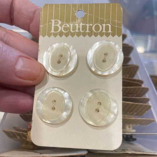 Card with four buttons held by a hand, with 'Beutron' branding visible