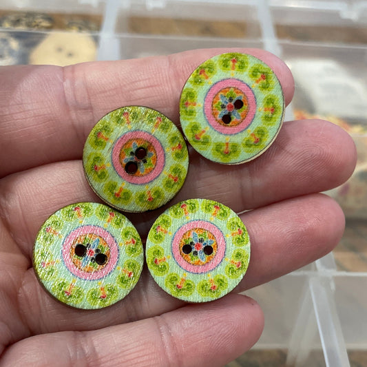 Hand holding four colorful buttons with a transparent container in the background