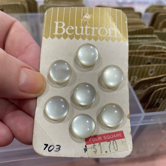 Card with buttons held by a hand, featuring the brand 'Beutron'.