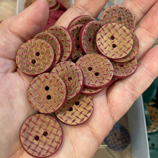 Hand holding a collection of brown buttons with a blurred background