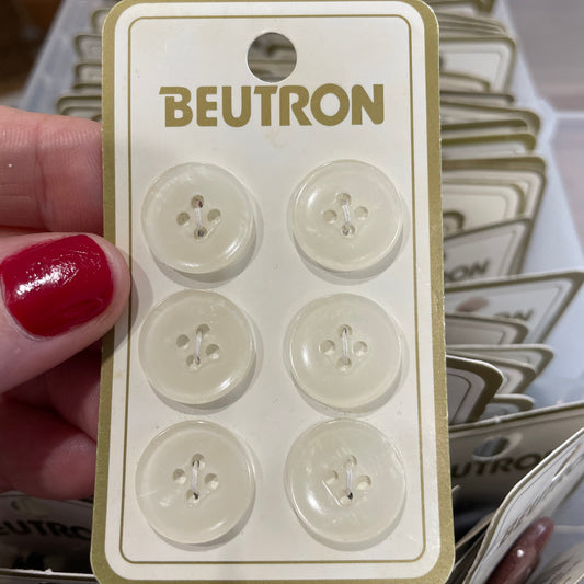 Pack of buttons with 'Beutron' branding held by a hand.