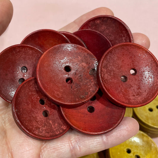 Hand holding red buttons with a keyboard in the background