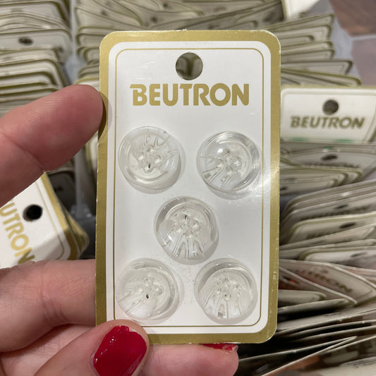 Packaged buttons with 'Beutron' branding held by a hand.