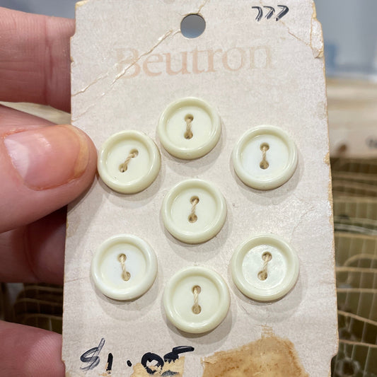 Card with eight white buttons held by a hand against a blurred background