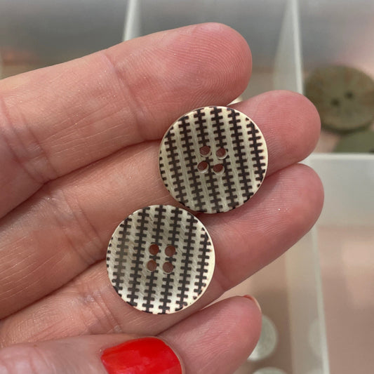 Buttons held by a hand with a blurred background of buttons.