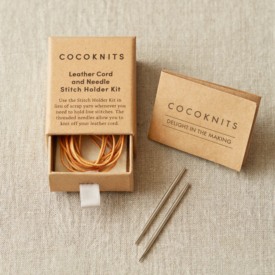 Cocoknits leather cord and needle stitch holder kit on a beige fabric background